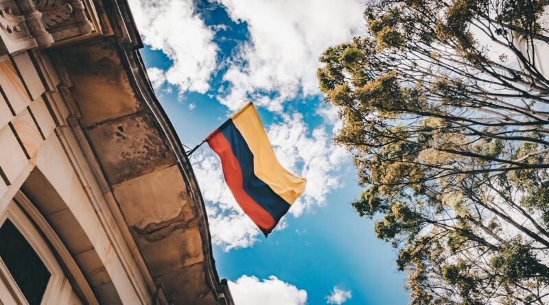 bandera de Colombia ondea en el techo de una edificación que se observa en plano contrapicado