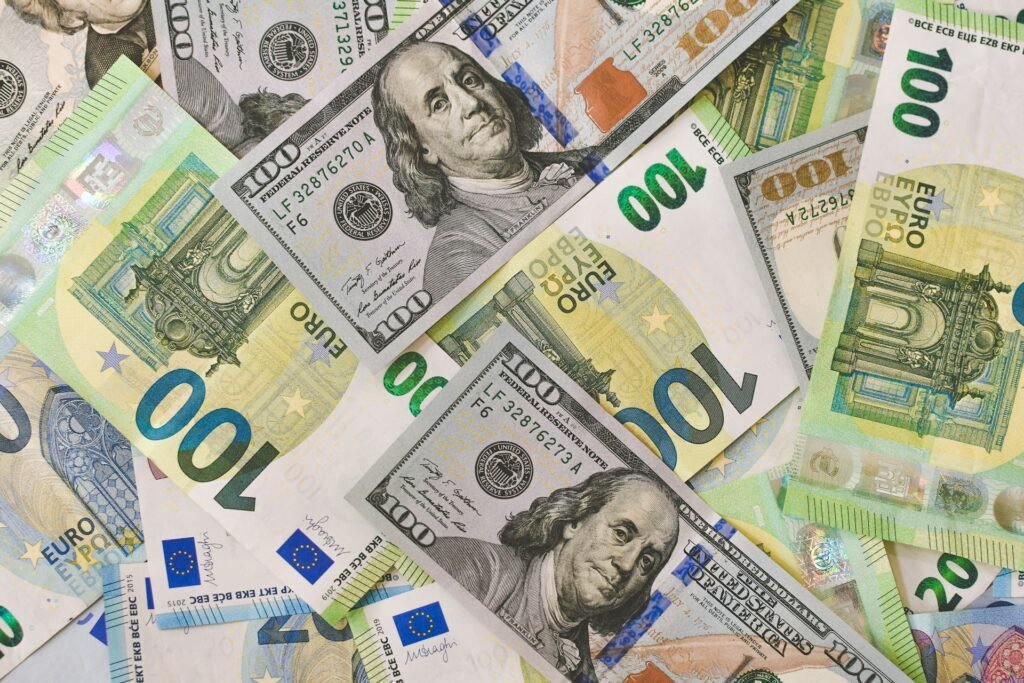 billetes de euros y dólares están regados y dispuestos sobre una mesa.