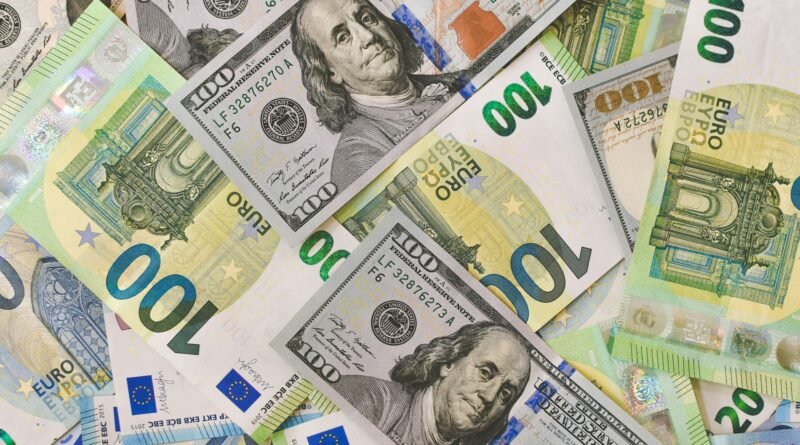 billetes de euros y dólares están regados y dispuestos sobre una mesa.