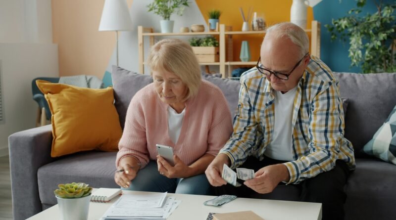 pareja de la tercera edad se observan contando dinero en efectivo en la sala de su casa