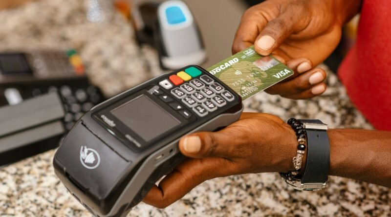 cajero introduce una tarjeta en un punto de venta para procesar una transacción