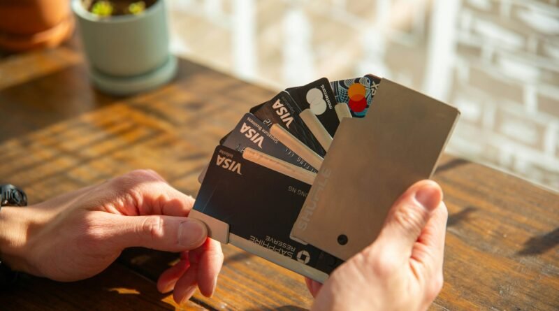 Una persona muestra una cartera de caballero en la que están dispuestas varias tarjetas Visa y Mastercard